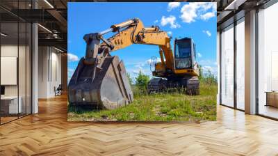 yellow tractor on green field and blue sky Wall mural