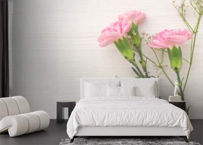 Decorative frame with pink carnations and white hazel on white wood background Wall mural