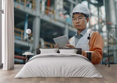 Asian man engineer is standing at plant the production of concrete. Confident asian engineer man Using tablet for checking and maintenance to inspection new project. copy space for text. Wall mural