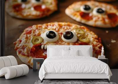 Monster face pizzas with olive eyes and pepperoni mouths. copy space for text. Wall mural