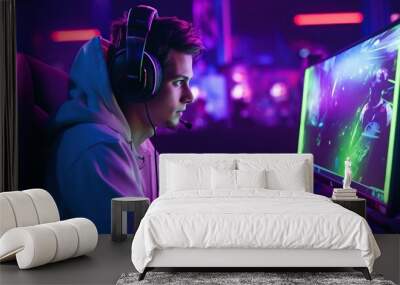 Teenager wearing headphones and playing online video games. Wall mural