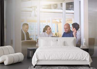 Corporate business meeting in modern office with glass walls, flare from the sunlight and reflections on the glass while business discussions take place amongst board members. Wall mural