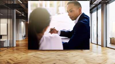 over the shoulder shot of handsome businessman busy talking to his female colleague during their sch Wall mural