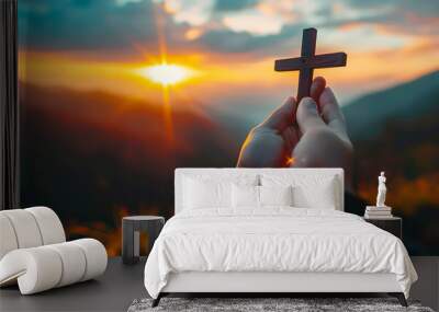 Silhouette of hands presenting Christian cross against sunset Wall mural