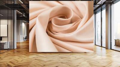 The monophonic fabric of beige color showing a beautiful drapery a spiral. Wall mural