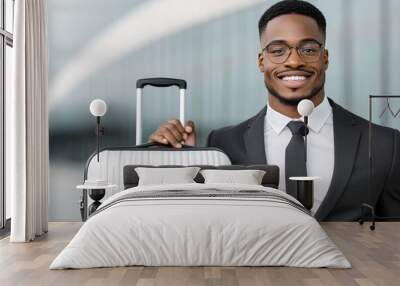 A man in a suit and tie is smiling and holding a suitcase Wall mural