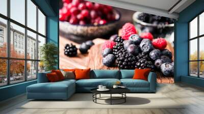 blueberries and raspberries on a wooden background Wall mural