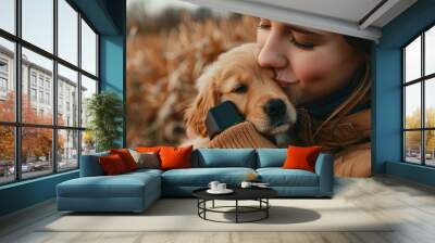 a woman holding a puppy and a cell phone Wall mural