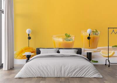 Fresh mango smoothie and ripe mango slice on color background. summer drink. Wall mural