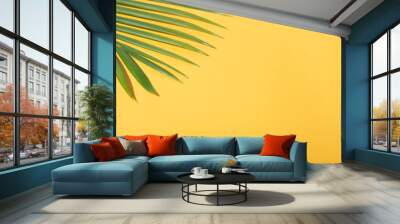 Green tropical palm leaves on yellow background with sunlight. Minimal summer creative flat lay. Wall mural