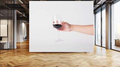 hand holding red wine glass on a white background. Wall mural