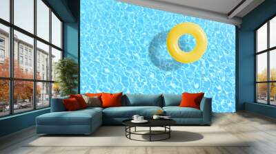 yellow swimming pool ring float in blue water. concept color summer. Wall mural