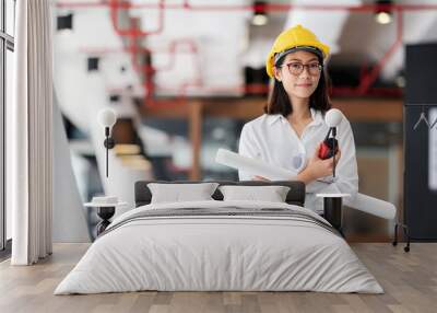 Beautiful female engineer standing in office. Wall mural