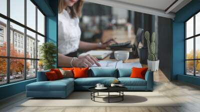 Businesswoman working at office with documents on her desk, doing planning analyzing the financial report Wall mural