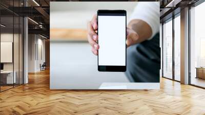 Closeup view of business man showing blank screen mobile phone in office. Wall mural