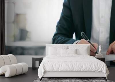 Cropped shot of businessman in suit writing business papers at desk in modern coworking office. copy space Wall mural