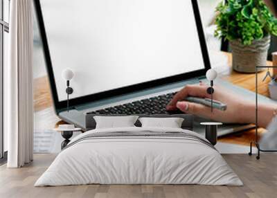 Cropped shot of woman hand working on laptop computer and peper work while sitting at the table. Wall mural