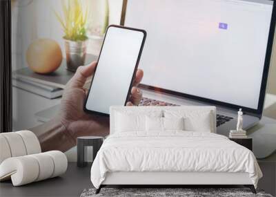 Man sitting at office desk and using the mobile smartphone. Wall mural