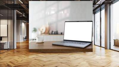 Open laptop with blank screen on a wooden desk in a kitchen room home office Wall mural