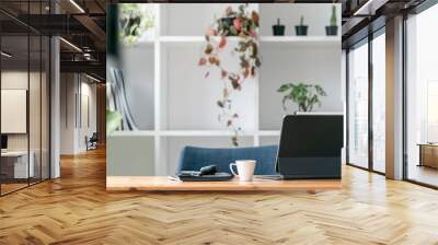 Rear view of computer tablet with magic keyboard and gadget on wooden table in living room with copy space. Wall mural