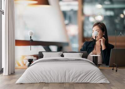 Thoughtful businesswoman sitting at work place. Wall mural