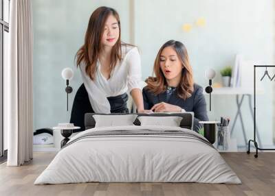 Young attractive businesswomen working with laptop on new project together in modern office. Wall mural