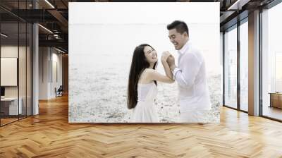 Young Asian couple in love on the beach. Wall mural