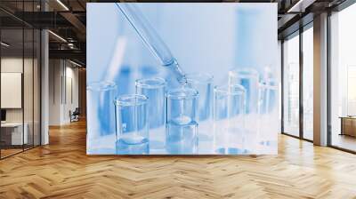 A pipette that adds fluid to one of several tubes. Lab tests Wall mural