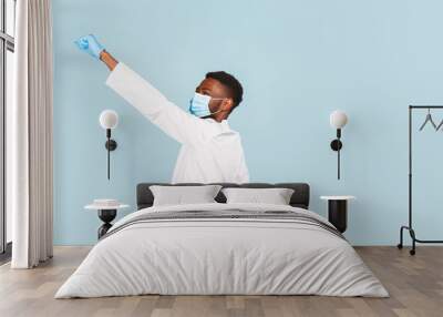 happy African American male doctor with stethoscope wearing mask and gloves on blue background. winner Wall mural