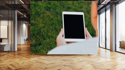 male hands holds digital pc t mock up for your text message or informational content, on the background of green nature Wall mural