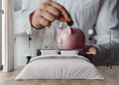 male hands put a coin in a pink piggy bank. The concept of saving money or savings, investment. world crisis Wall mural