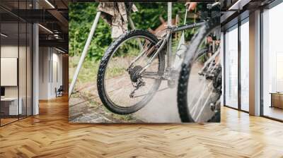 A man high-pressure washing a dirty mountainbike Wall mural