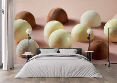  A sleek arrangement of white wine and milk chocolate truffles on a smooth, pastel-colored ba Wall mural