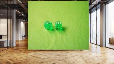 A vibrant monochromatic macro with depth of field about two green glass gambling dice with two lucky number six on green background. Wall mural