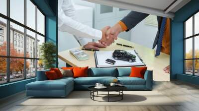 close-up of a car salesman handing the keys to an Asian customer after signing an insurance agreement. business transaction, ownership and customer service in the automotive industry. Wall mural