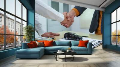 close-up of a car salesman handing the keys to an Asian customer after signing an insurance agreement. business transaction, ownership and customer service in the automotive industry. Wall mural