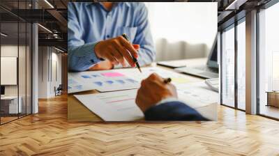 Desk-bound businessman calculates figures, verified accounts, and collaborates in discussions. Proficient in using calculators, aiding each other, and managing annual tax accounts in the audit office Wall mural