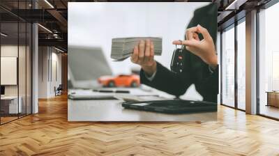 Pretty Asian businesswoman confidently handling funds for new vehicle loan, depicting financial independence and pursuit of luxury, success, modern transportation. lending money on new car loan Wall mural