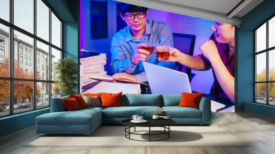 Two men are working late at the office, drinking beer while checking documents. They are overwhelmed with a lot of work, tired, and stressed as they continue to work through the night. Wall mural