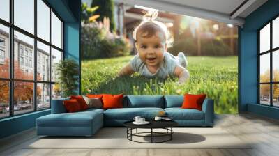 Baby crawling on the grass in a sunny backyard Wall mural