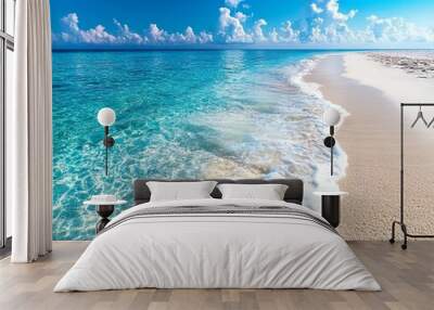 Idyllic tropical beach with clear turquoise water, gentle waves, and a pristine sandy shore under a bright blue sky with fluffy white clouds. Wall mural