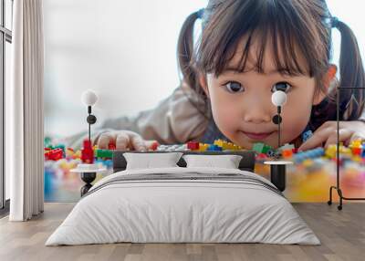 Happy little girl surrounded by colorful lego blocks. Wall mural