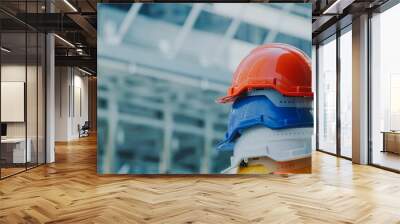 Orange, blue, white and yellow hard safety helmet hat. Engineer, Construction and Safety Concept. Wall mural