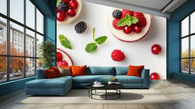 A vanilla mousse dessert, garnished with fresh berries and mint leaves, placed on a plain white background. Wall mural