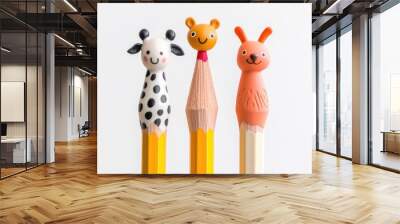 An artistic display of three uniquely shaped pencils with cute animal toppers, set against a bright white background Wall mural