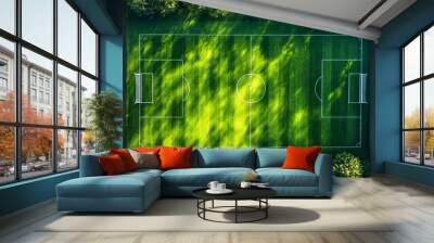 Aerial view of a well-maintained soccer field surrounded by greenery, showcasing bright green grass and clear pitch markings. Perfect for sports enthusiasts. Wall mural