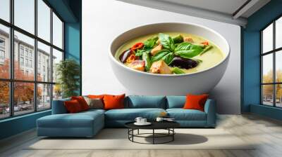 A delicious bowl of green curry soup featuring tender chicken, fresh basil, and vibrant vegetables, creating delightful and aromatic dish. Wall mural