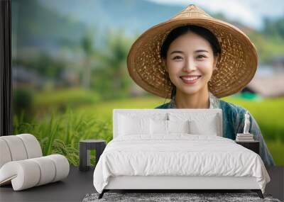 A woman in straw hat smiles brightly in lush green rice field, showcasing beauty of rural life and agriculture. vibrant landscape adds to serene atmosphere. Wall mural