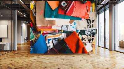 A photo of a mood board filled with magazine clippings, fabric swatches, color swatches, and paint chips. The composition is arranged on a textured surface with ample negative space for text. Wall mural