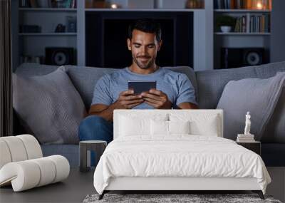 Man relaxing on a sofa, adjusting home theater settings with a mobile device, surround sound system visible, evening scene, copy space for text, Wall mural